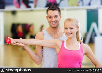 fitness, sport, training, gym and lifestyle concept - male trainer with woman working out with dumbbell