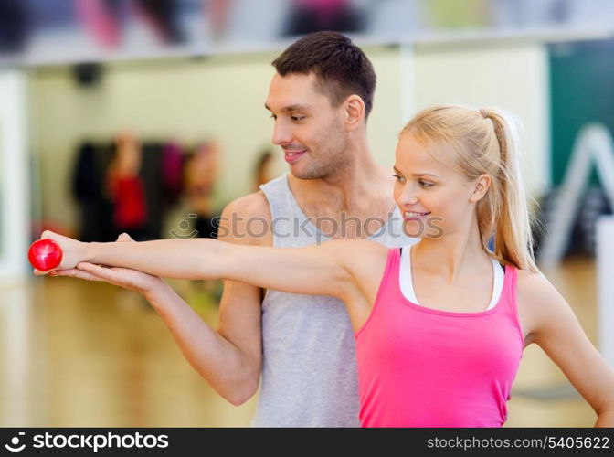 fitness, sport, training, gym and lifestyle concept - male trainer with woman working out with dumbbell