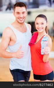 fitness, sport, training, gym and lifestyle concept - two smiling people in the gym