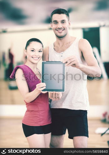 fitness, sport, training, gym and lifestyle concept - two smiling people showing blank tablet pc screen