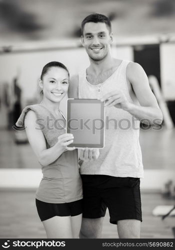 fitness, sport, training, gym and lifestyle concept - two smiling people showing blank tablet pc screen