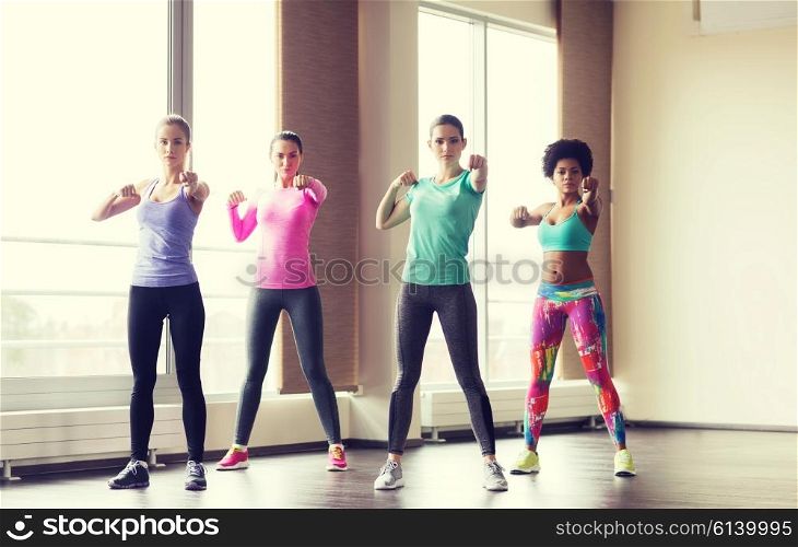 fitness, sport, training, gym and martial arts concept - group of women working out and fighting in gym