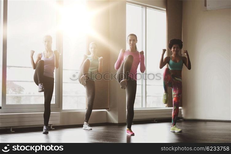 fitness, sport, training, gym and martial arts concept - group of women working out and fighting in gym