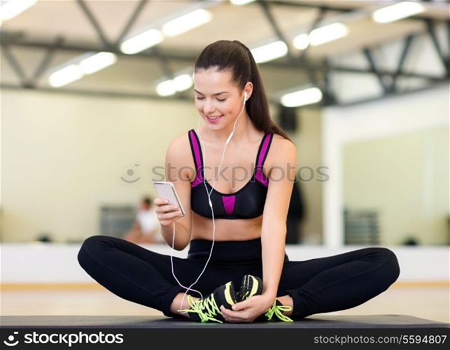 fitness, sport, training, gym, technology and lifestyle concept - smiling woman with smartphone