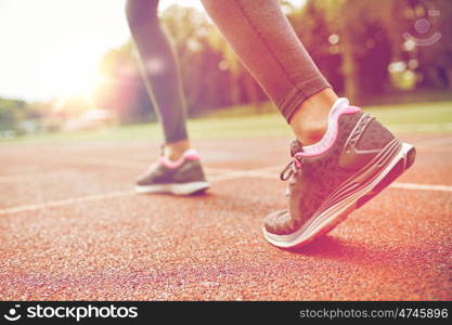 fitness, sport, training, people and lifestyle concept - close up of woman feet running on track from back. close up of woman feet running on track from back