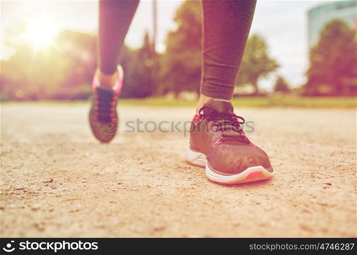 fitness, sport, training, people and lifestyle concept - close up of woman feet running on track from back