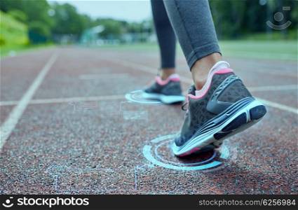 fitness, sport, training, people and lifestyle concept - close up of woman feet running on track from back with futuristic holograms