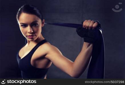 fitness, sport, training, people and lifestyle concept - woman doing exercises with expander or resistance band in gym. woman with expander exercising in gym