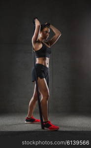 fitness, sport, training, people and lifestyle concept - woman doing exercises with expander or resistance band in gym