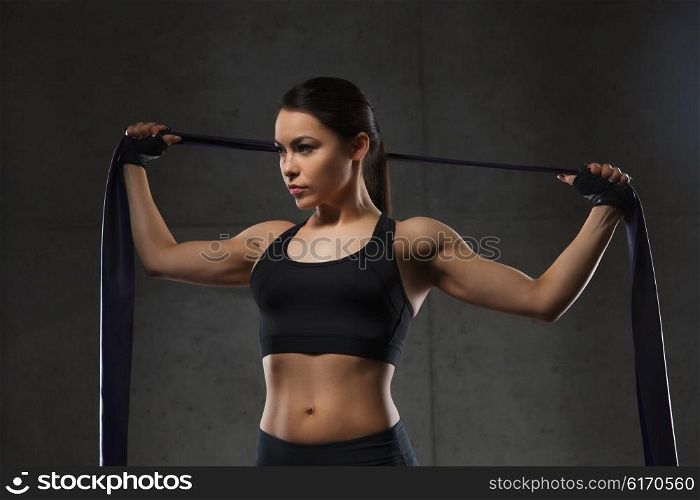 fitness, sport, training, people and lifestyle concept - woman doing exercises with expander or resistance band in gym
