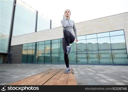 fitness, sport, training, people and lifestyle concept - young woman making step exercise on city street bench