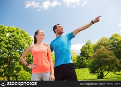 fitness, sport, training, technology and lifestyle concept - two smiling people outdoors