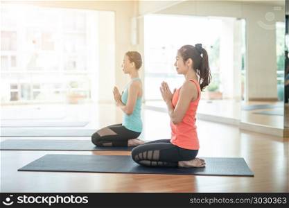 fitness, sport, training, yoga and people concept - Asian woman do exercise in gym.Group Of female Doing Yoga Indoors