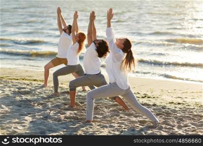fitness, sport, yoga and healthy lifestyle concept - group of people making high lunge or crescent pose on beach