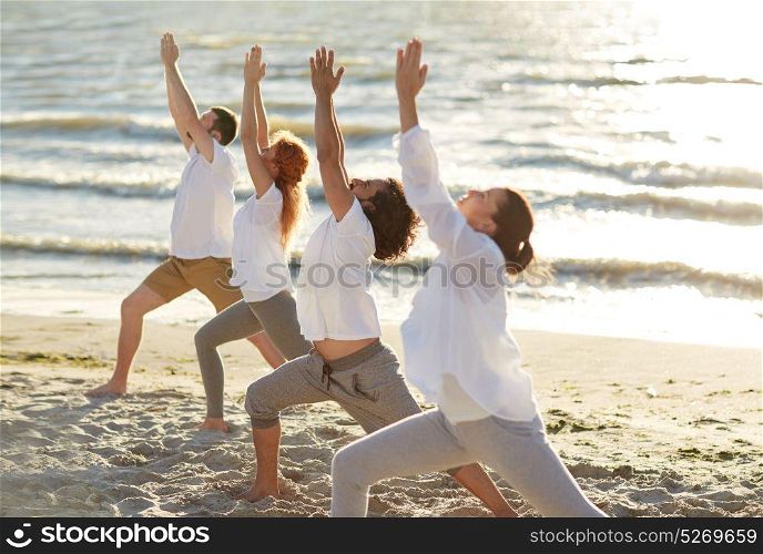 fitness, sport, yoga and healthy lifestyle concept - group of people making high lunge or crescent pose on beach. group of people making yoga exercises on beach