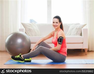 fitness, sportm home and dieting concept - smiling teenage girl with armband execising at home