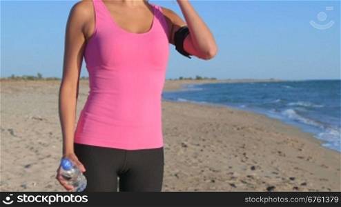 Fitness sporty woman training outdoors taking break to drink water