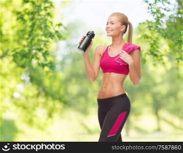 fitness, spot and people concept - happy smiling sporty woman drinking water from bottle over green natural background. sporty woman drinking water from bottle