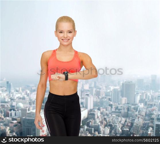 fitness, technology and exercising concept - smiling woman with heart rate monitor on hand