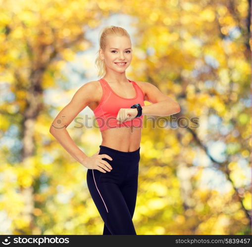 fitness, technology and exercising concept - smiling woman with heart rate monitor on hand