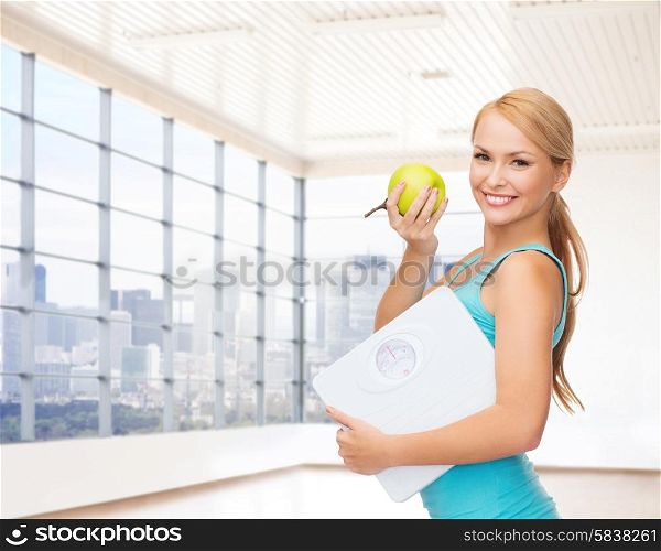 fitness, technology, people and sport concept - smiling woman with scale and green apple over gym or home background