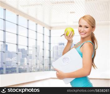 fitness, technology, people and sport concept - smiling woman with scale and green apple over gym or home background