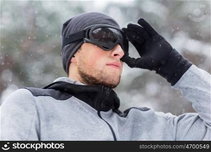 fitness, winter sport, people and healthy lifestyle concept - close up of young man in ski goggles outdoors