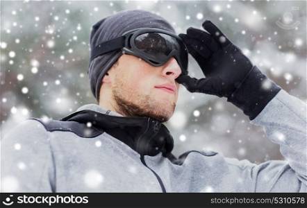 fitness, winter sport, people and healthy lifestyle concept - close up of young man in ski goggles outdoors. close up of sports man with ski goggles in winter