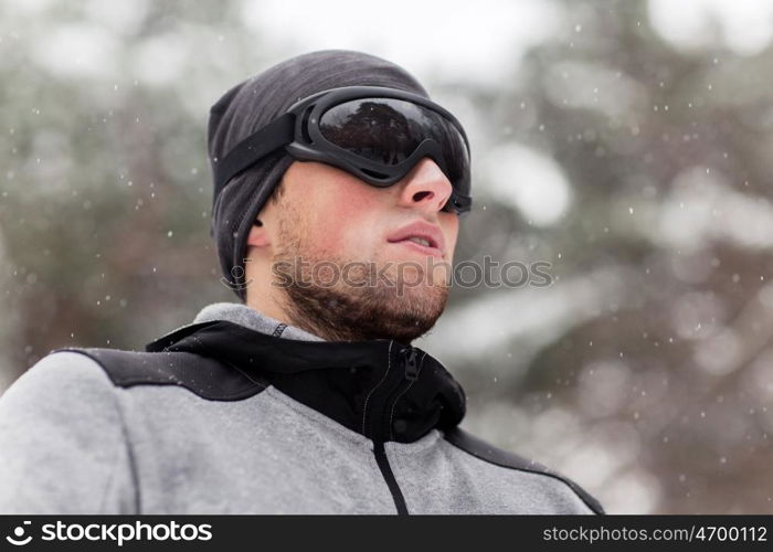 fitness, winter sport, people and healthy lifestyle concept - young man in ski goggles outdoors