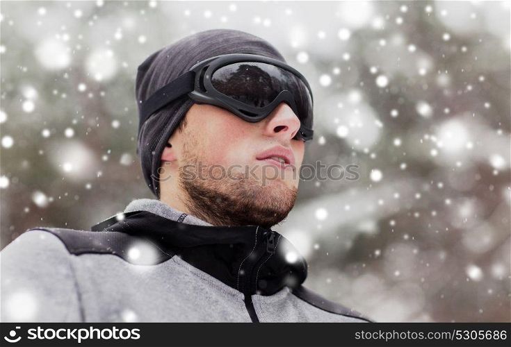 fitness, winter sport, people and healthy lifestyle concept - young man in ski goggles outdoors. sports man with ski goggles in winter outdoors
