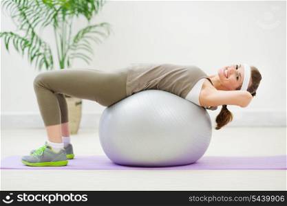 Fitness woman doing abdominal crunch on fitness ball