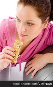 Fitness woman eat granola bar sportive outfit in gym