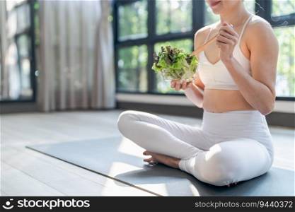 Fitness woman eating healthy salad after workout. training  in yoga studio healthy lifestyle concept.