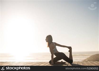 Fitness woman enjoying beautiful sunset on the beach