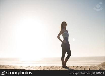 Fitness woman enjoying beautiful sunset on the beach