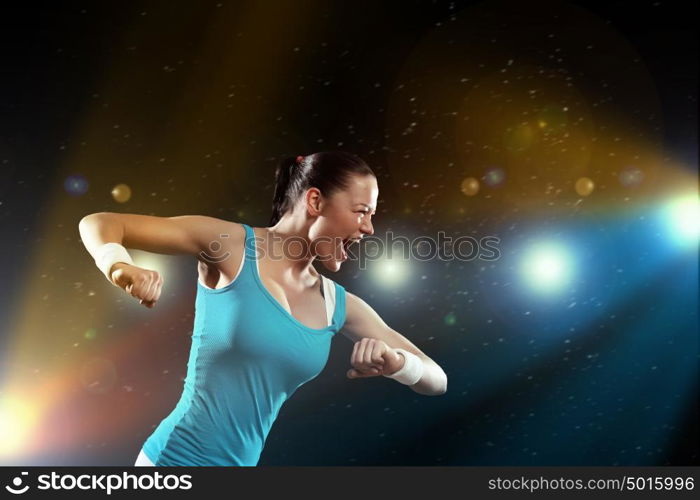 Fitness woman exercising. Image of sportswoman exercising against lights background