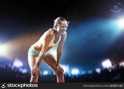 Fitness woman. Fitness woman standing against stadium lights background