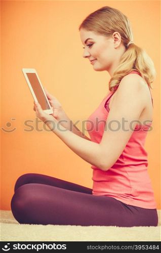 Fitness woman girl with tablet browsing internet.. Young woman using computer tablet browsing internet. Fitness sporty girl holding ebook. Technology leisure.