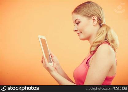 Fitness woman girl with tablet browsing internet.. Young woman using computer tablet browsing internet. Fitness sporty girl holding ebook. Technology leisure.