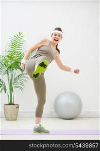 Fitness woman in sportswear kicking