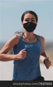 Fitness woman in tight sporty clothes wearing black protective face mask running outdoors in the city during coronavirus outbreak. Covid 19 and physical jogging activity, sport and fitness. New normal. Determined fitness woman in short clothes wearing red protective face mask running outdoors in the city during coronavirus outbreak. Covid 19 and physical jogging activity, sport and fitness.