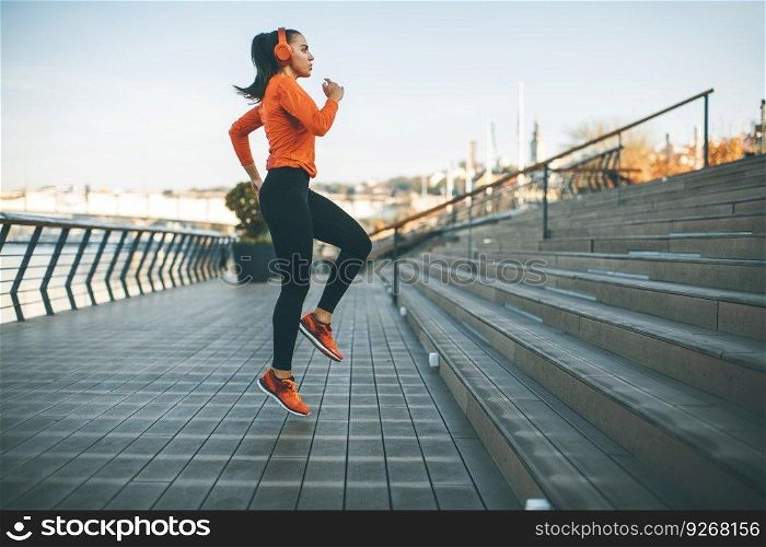 Fitness woman jumping outdoor in urban enviroment