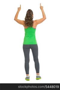 Fitness woman pointing up on copy space . rear view