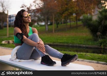 Fitness woman runner relaxing in the city park