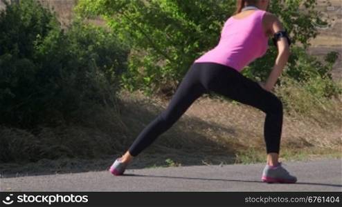 Fitness woman runner stretching before run on the road
