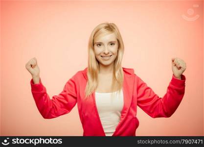 Fitness woman showing fresh energy flexing biceps muscles smiling closed eyes. Girl in sportwear energetic and fun