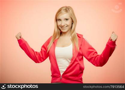 Fitness woman showing fresh energy flexing biceps muscles smiling closed eyes. Girl in sportwear energetic and fun