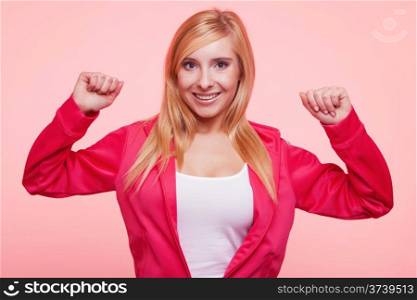 Fitness woman showing fresh energy flexing biceps muscles smiling happy on pink background. Girl in sportwear energetic and fun.
