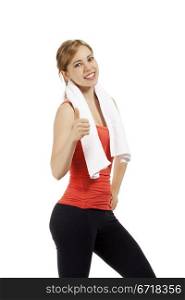 fitness woman showing thumb up. happy young fitness woman with a white towel showing thumb up on white background