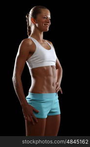 Fitness woman smiling. Fitness woman smiling standing against black background